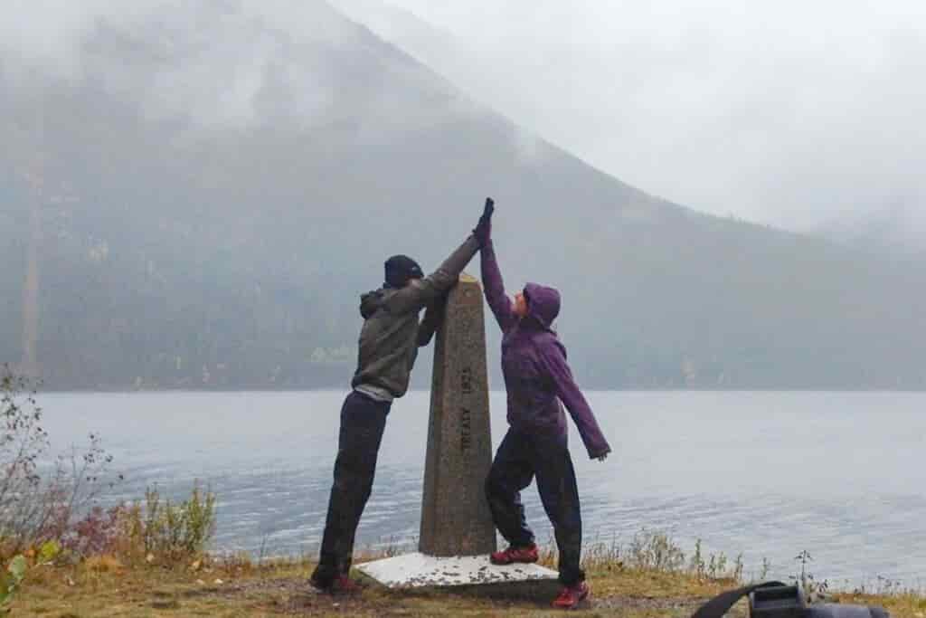 Two thru-hikers high-five at a trail terminus
