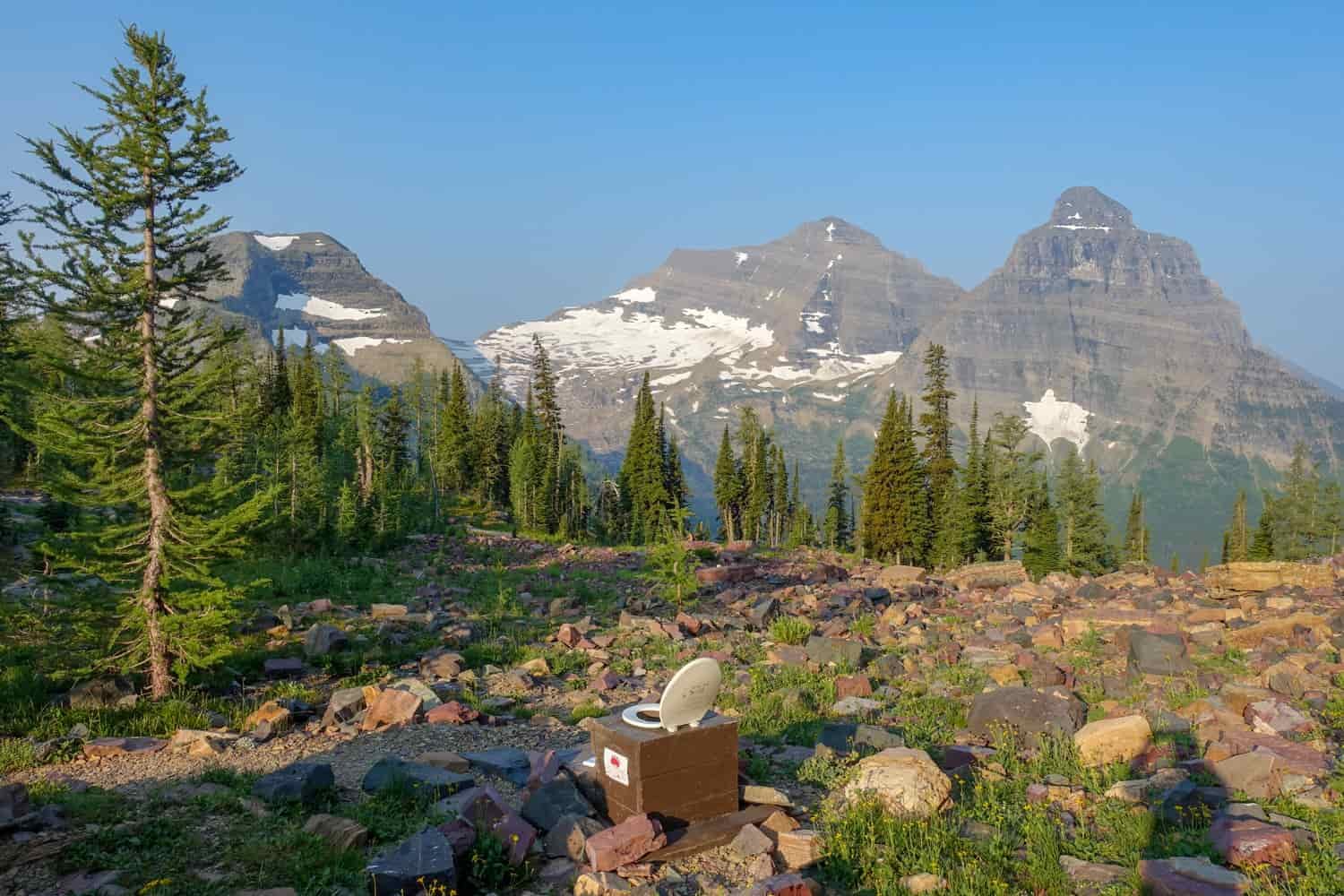 a backcountry toilet in glacier national park with a stunning view of the mountains
