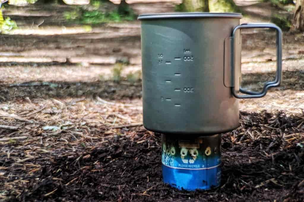a homemade camping stove from a beer can under a backpacking pot
