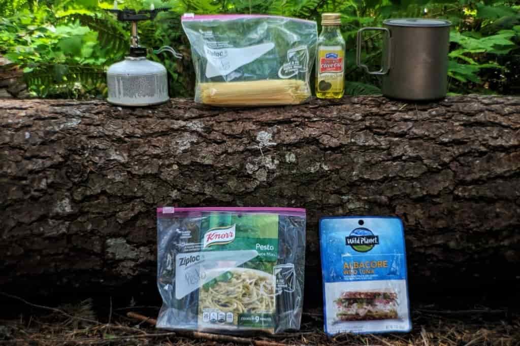 backpacking meals in ziplocks, stove, pot all resting on a log