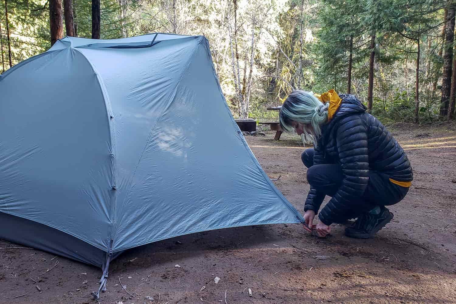 a solo backpacker sets up a sea to summit telos 2 tent in camp