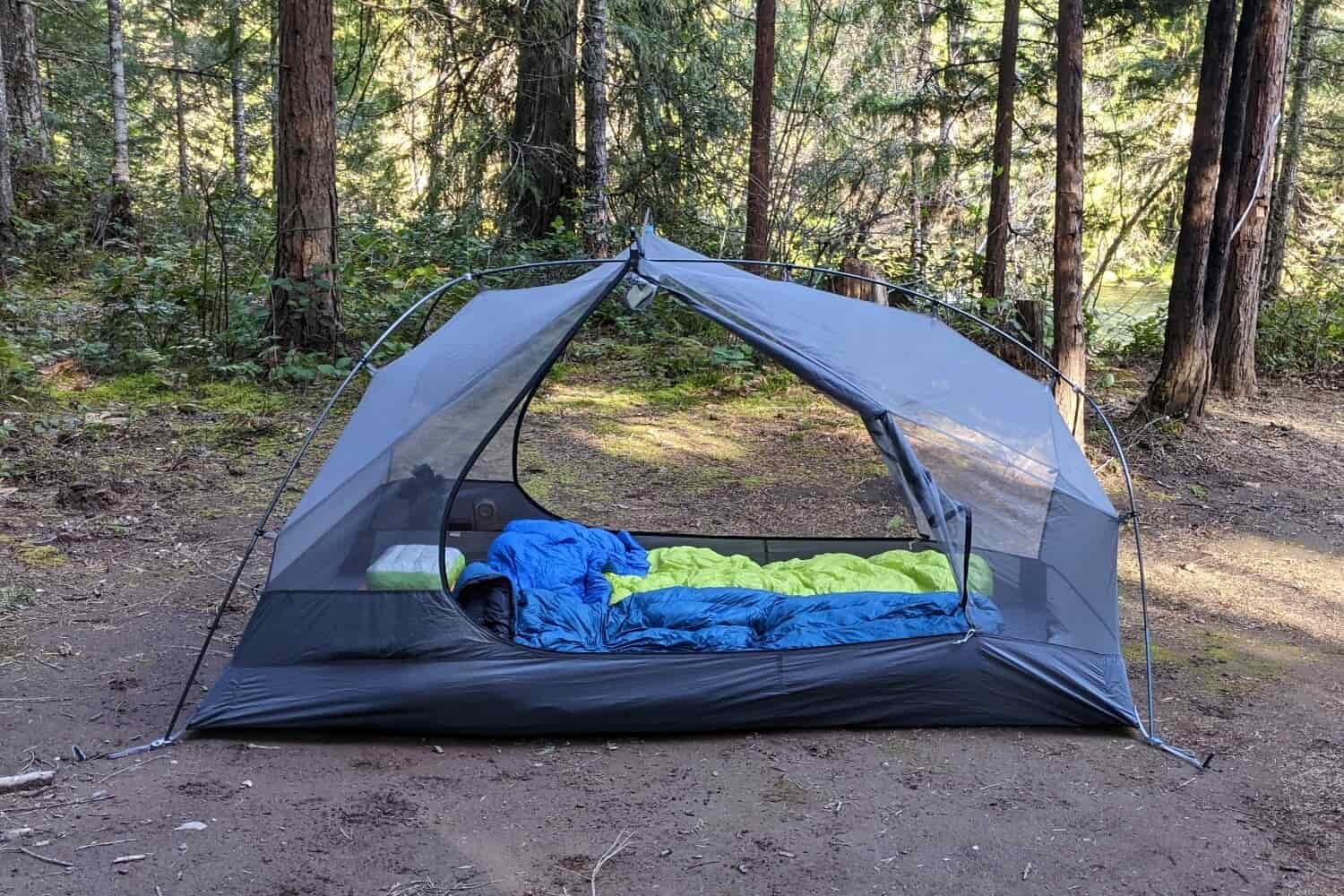 a backpacking tent pitched with sleeping gear in side and the doors unzipped