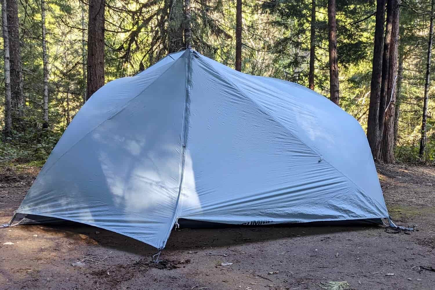 a sea to summit backpacking tent pitced in a sunlit forest