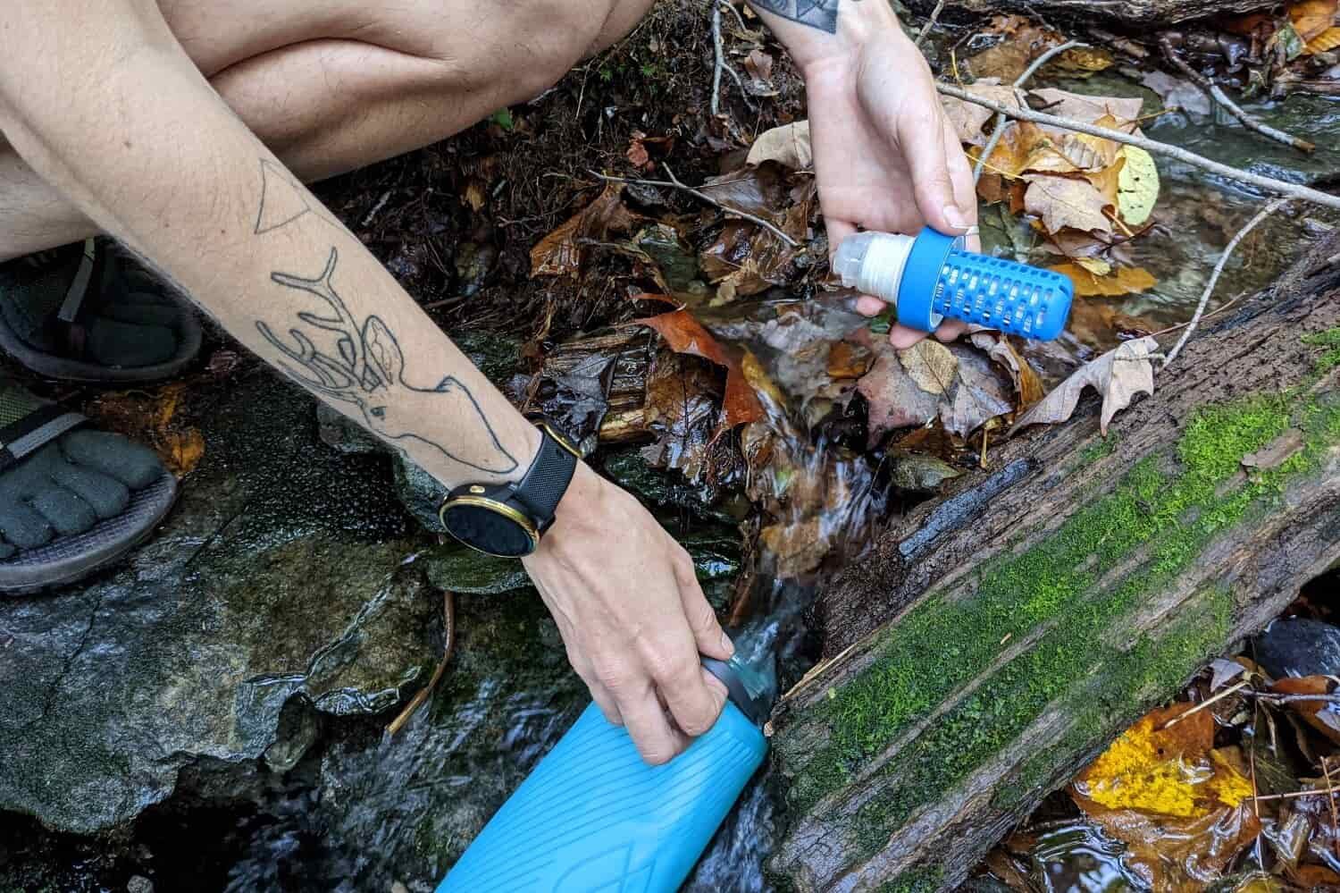 filling up the katadyn befree water filter from a small leafy stream on the long trail.