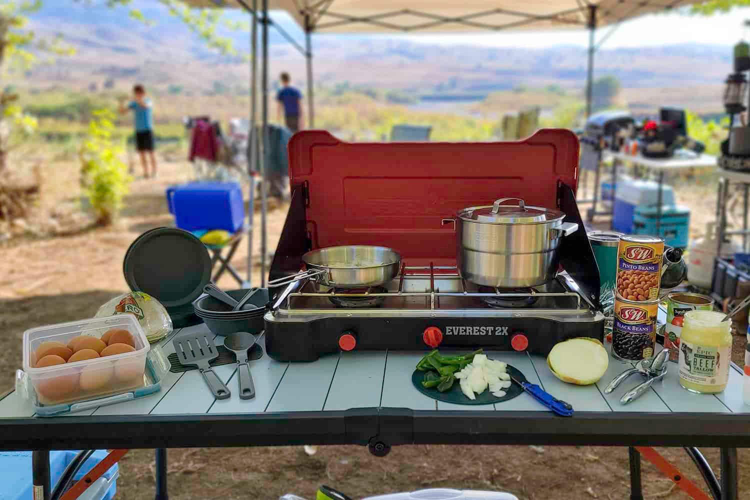 The Stanley Adventure Base Camp 4 Cookset with the Camp Chef Everest 2x stove on a table in a campsite
