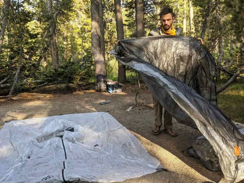 person checking their tent while it is not set up