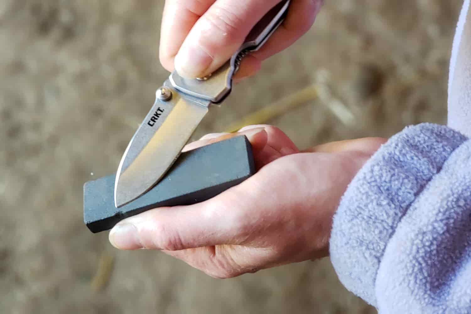 Closeup of a woman sharpening the CRKT Squid Pocket Knife