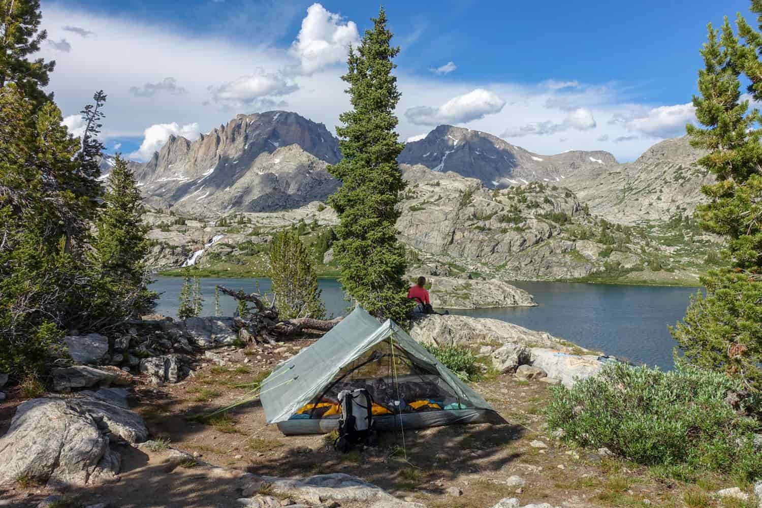 The Zpacks Triplex backpacking tent set up near a lake in Wyoming's craggy Wind River Range