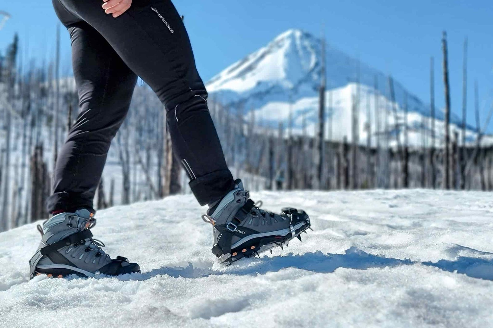 A hiker wearing the Kahtoola K-10 traction devices with the Salomon Quest hiking boots