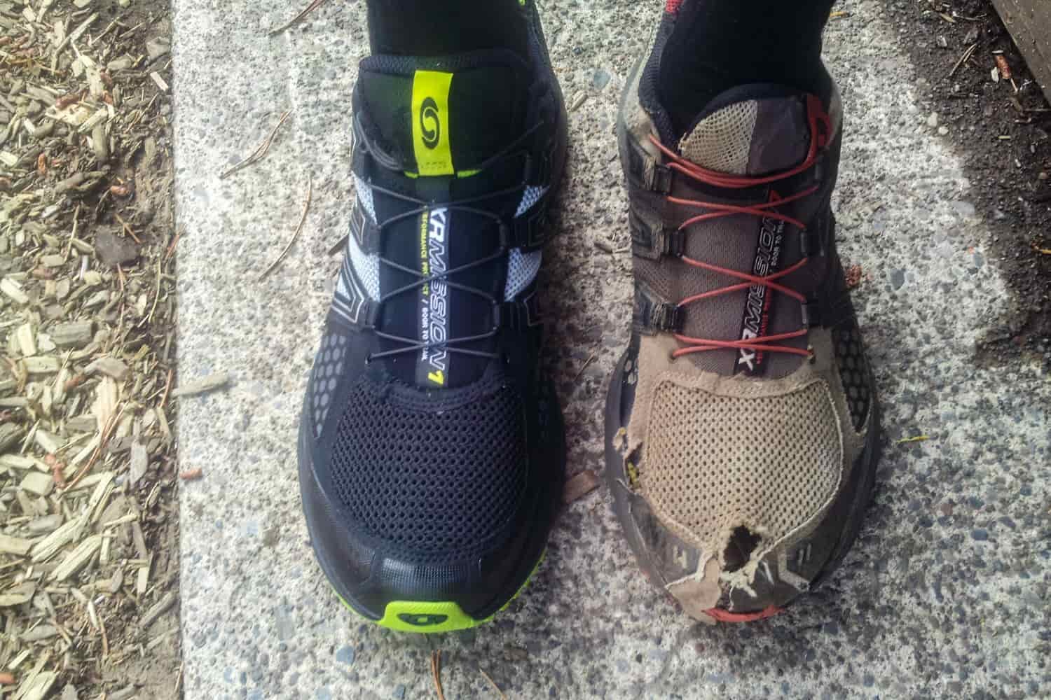 A hiker's feet - one with a brand new Salomon hiking shoe, and one in an old, worn out shoe