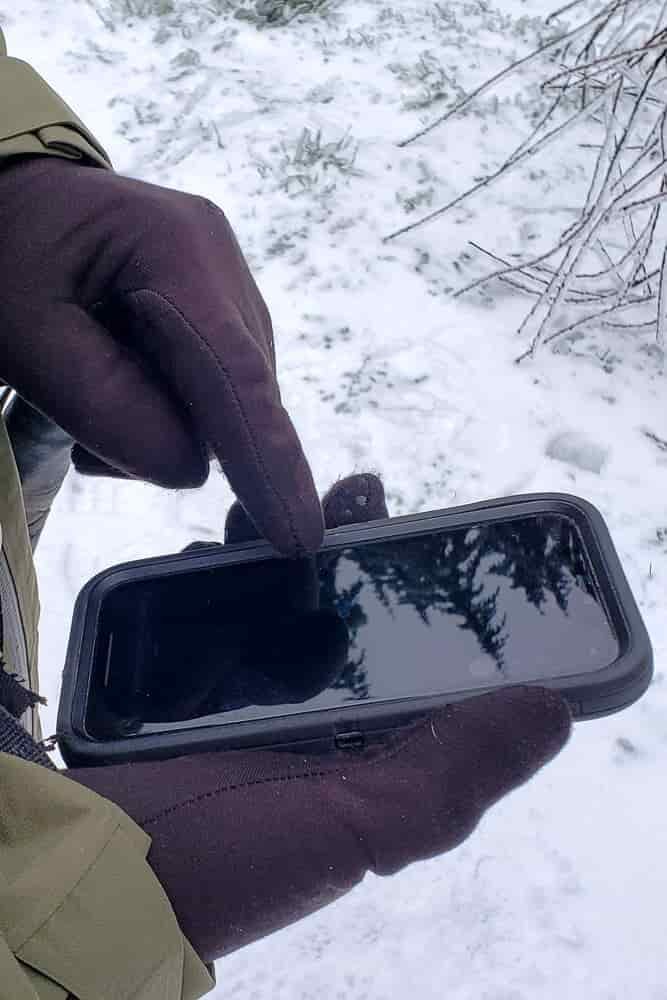 Closeup-of-someone-using-a-phones-touchscreen-with-gloved-hands