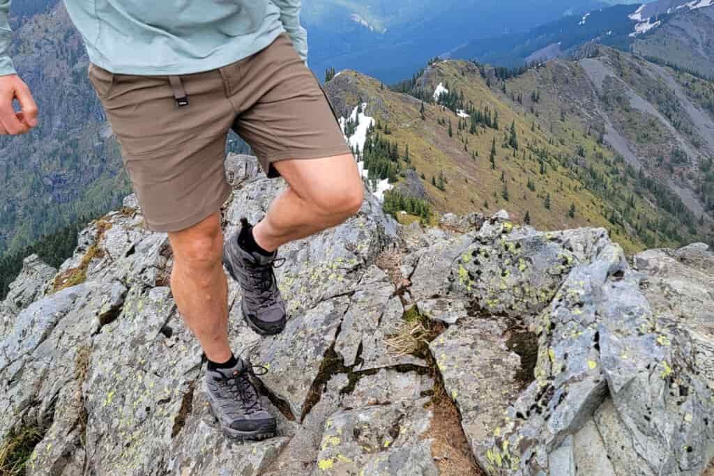 Waist-down view of a hiker traversing a rocky ridge in the Merrell Moab 3 hiking shoes