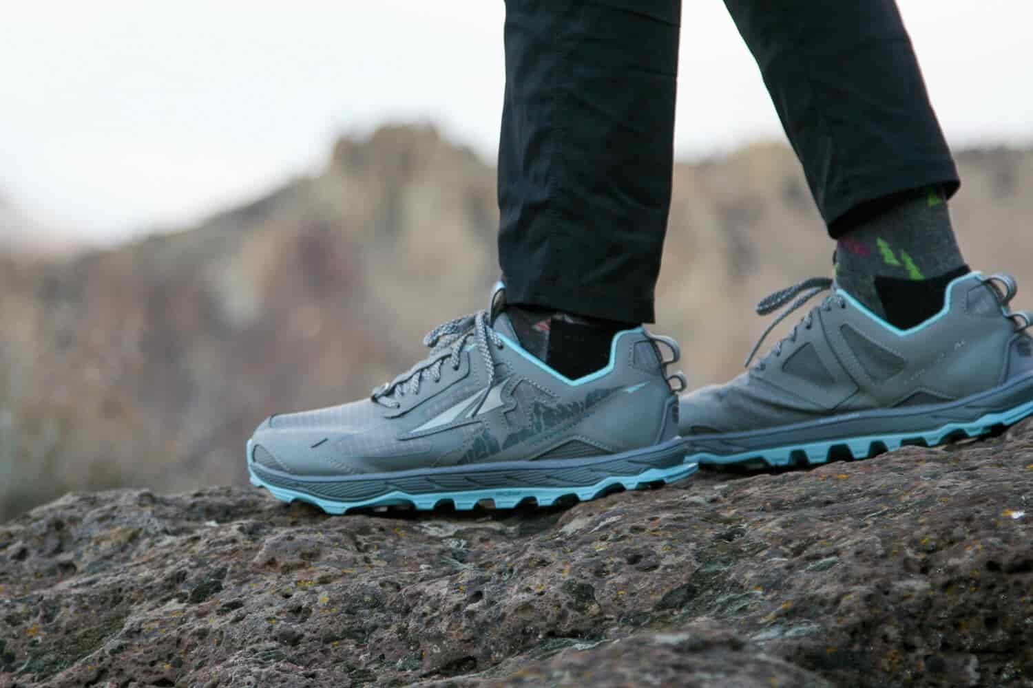 Close up shot of Altra Lone Peak trail running shoes on a rocky trail