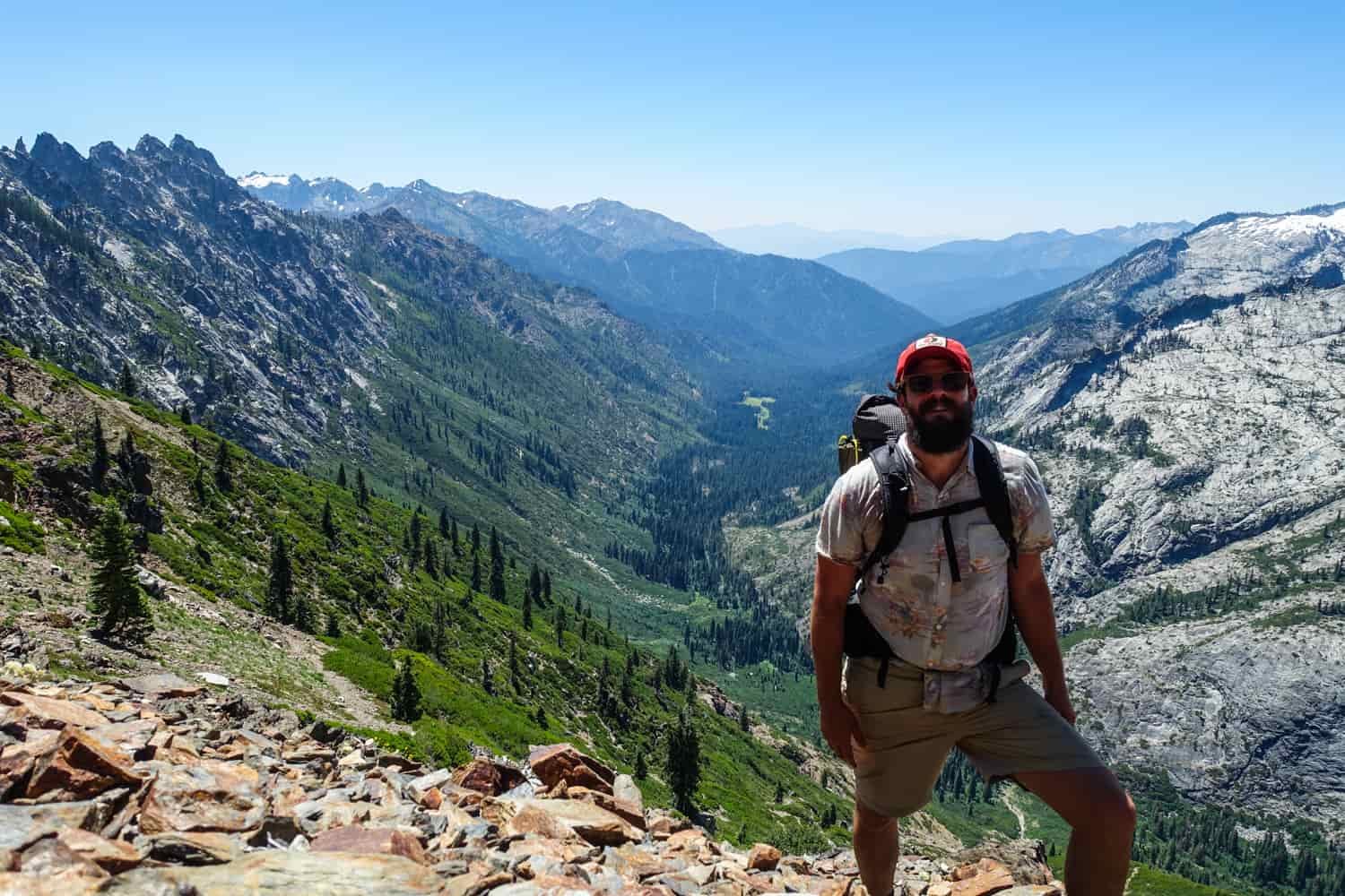backpacker in the trinity alps posing above a large drainage.