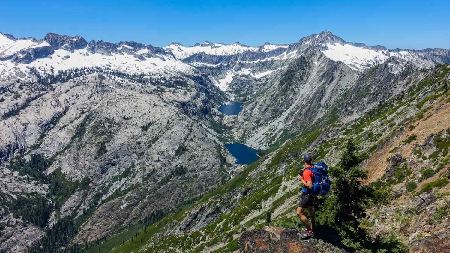 backpacker in the trinity alps high in the mountains with two glacial lakes in between the mountains