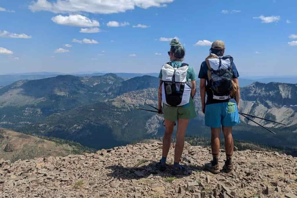two backpackers with their backpacks on overlooking the blue mountains from the strawberry mountains