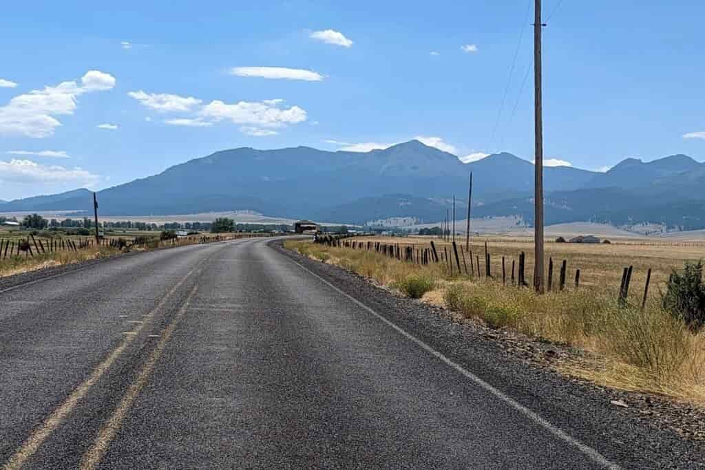 paved road leading to the rising strawberry mountains in eastern oregon