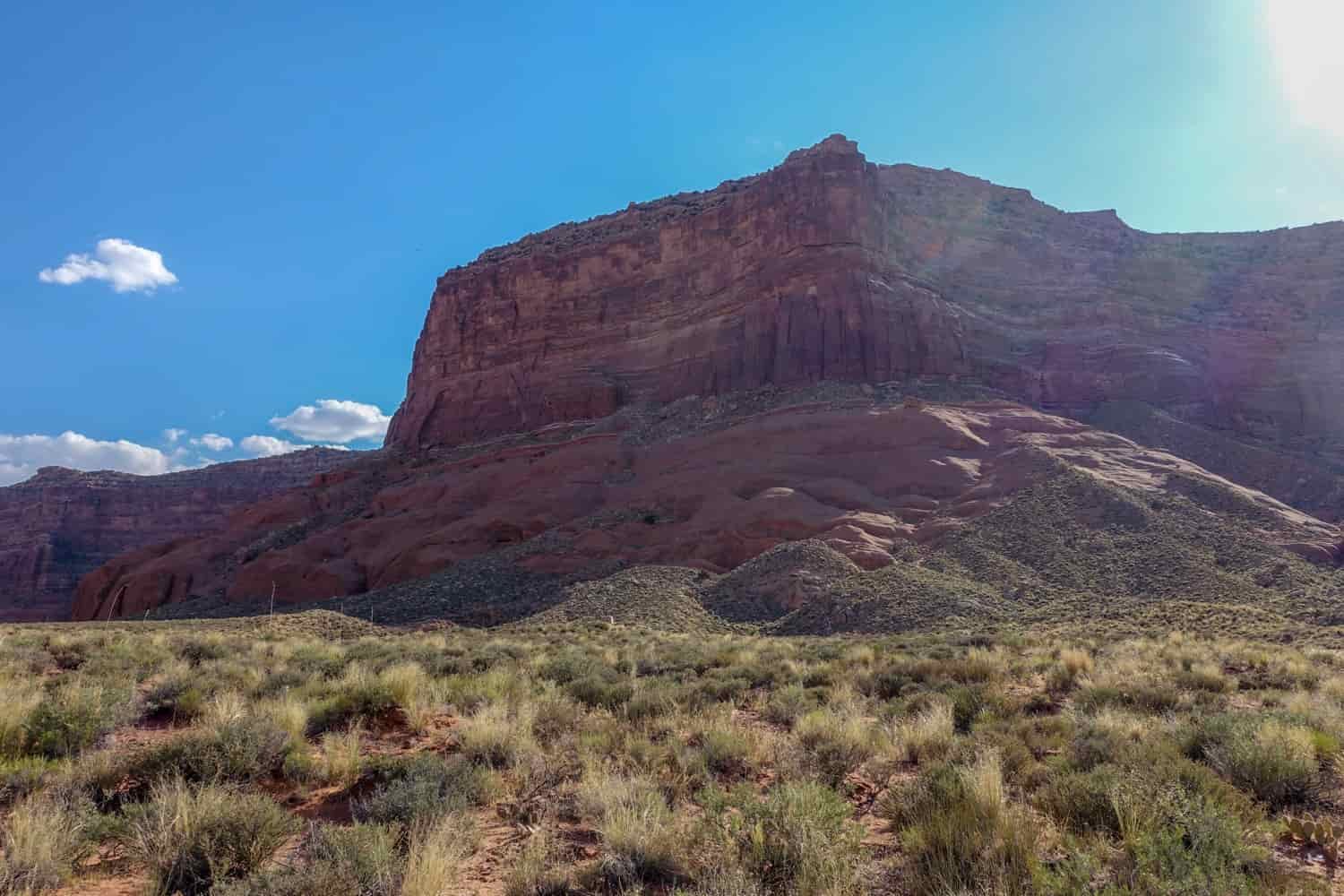a squared off butte with dramatic shadows and a bright blue sky