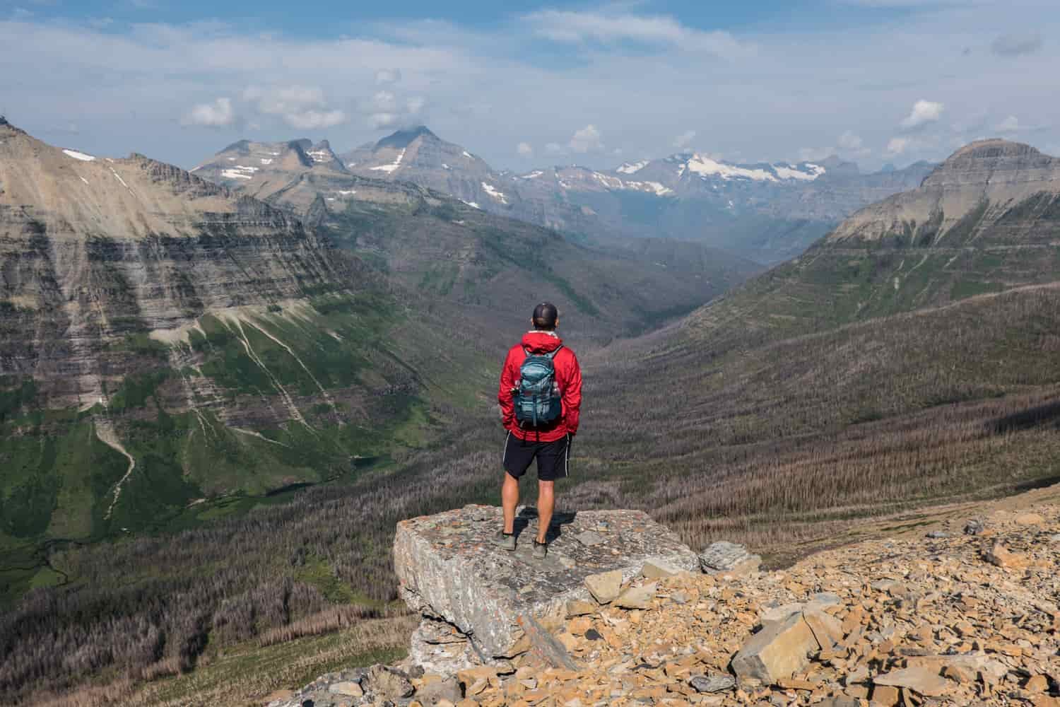 backpacker overlooking a valley created by a glacier.