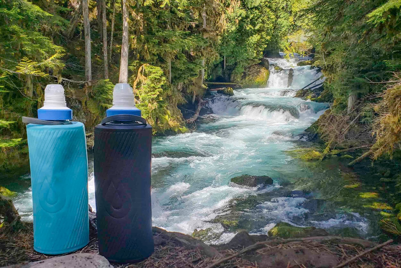 two water bottles and a water filter on a railing over the rapids and blue water of the mckenzie river