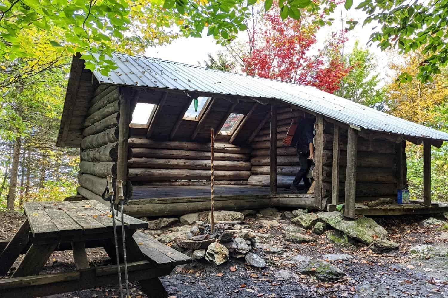 a shelter made from logs on the long trail with picnic table.