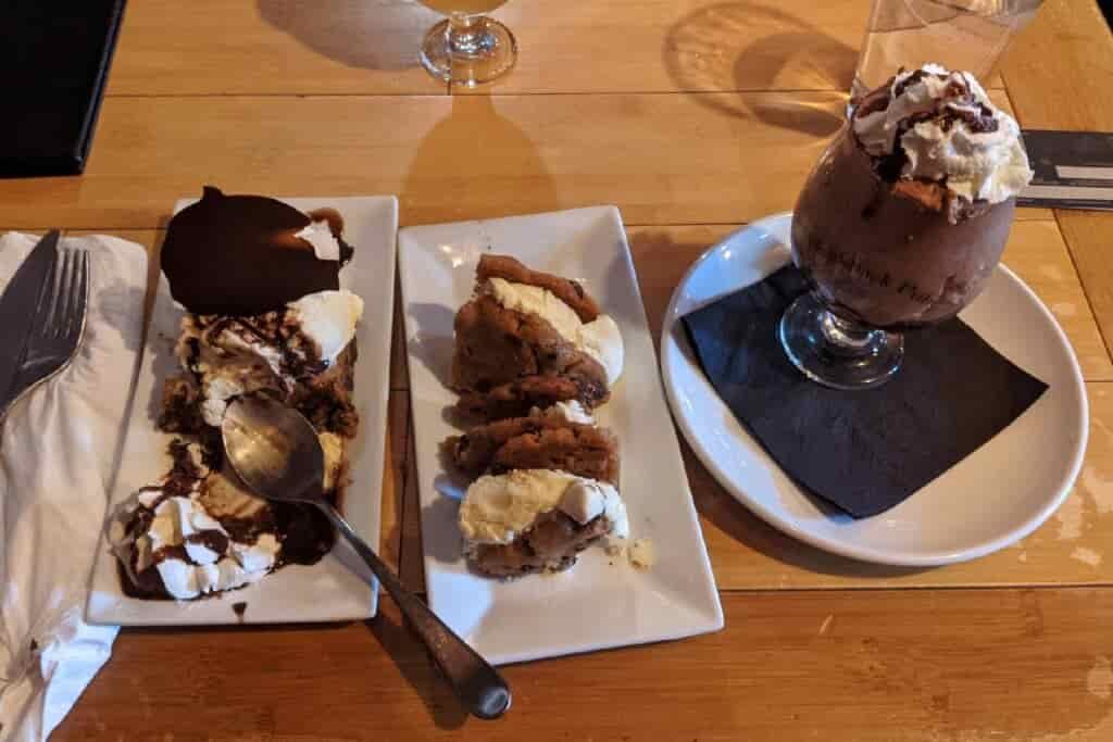 three desserts on a table (mousse, ice cream sandwiches, and pie)