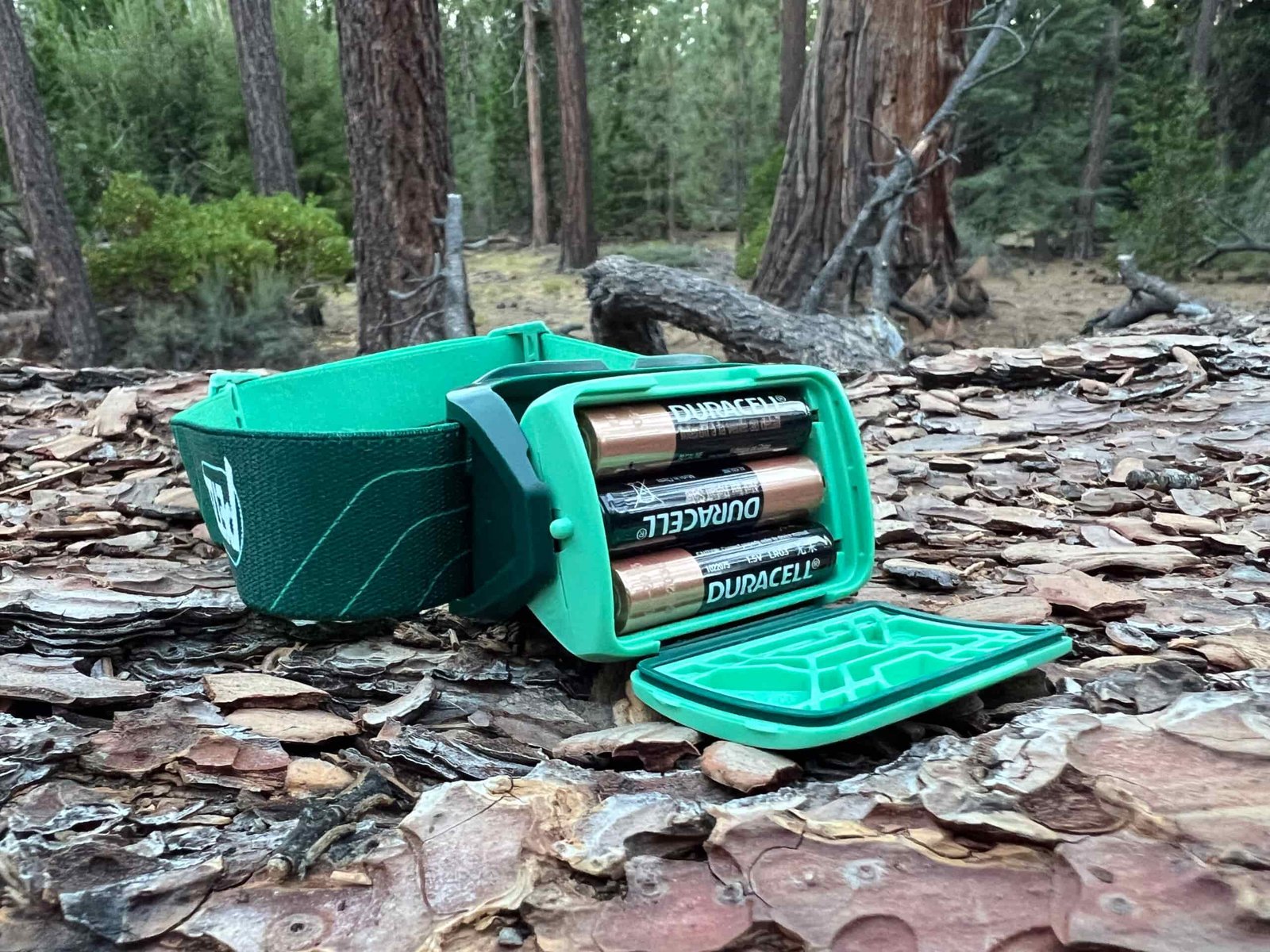 The image shows the battery compartment of the Petzl Tikkina with 3 AAA disposable batteries.