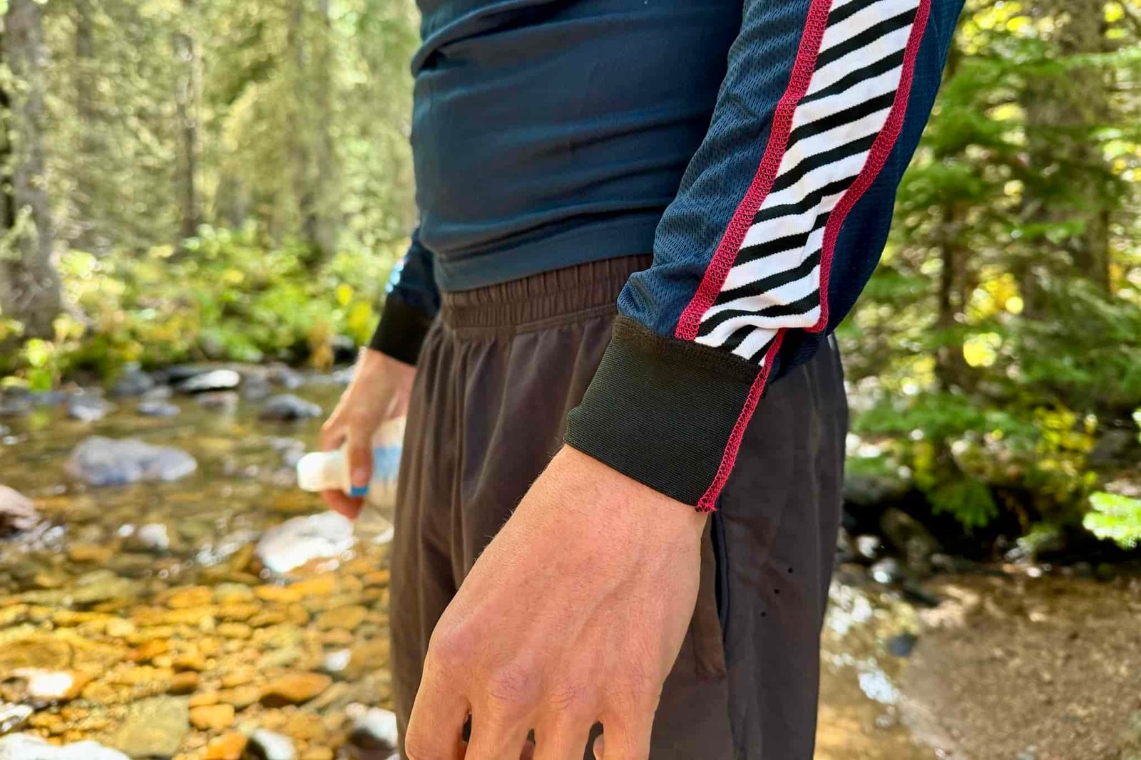 A close up of the wristbands on the Helly Hansen Lifa Stripe base layer. Trees and a creek are in the background.
