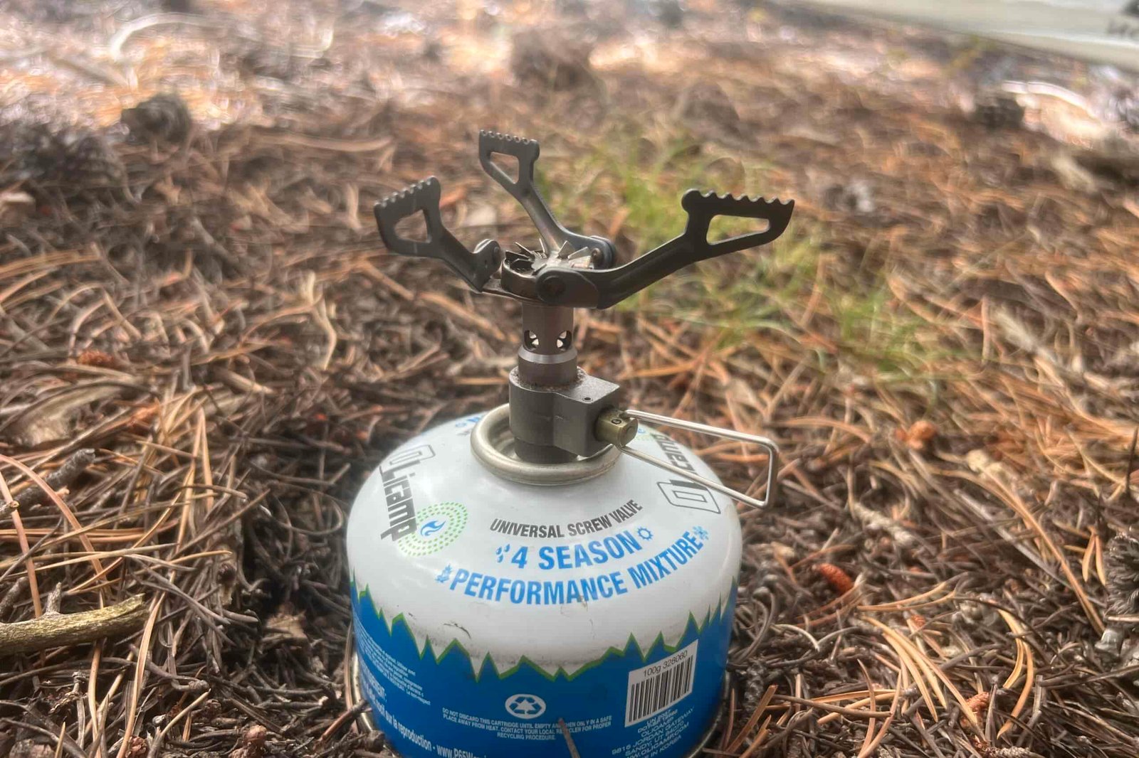 The BRS 3000T installed on a fuel canister with pine needles in the background