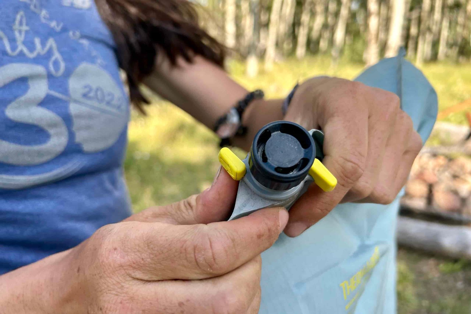 Close up of a person's hands opening a single valve on the Sea to Therm-a-Rest NeoAir XTherm NXT.