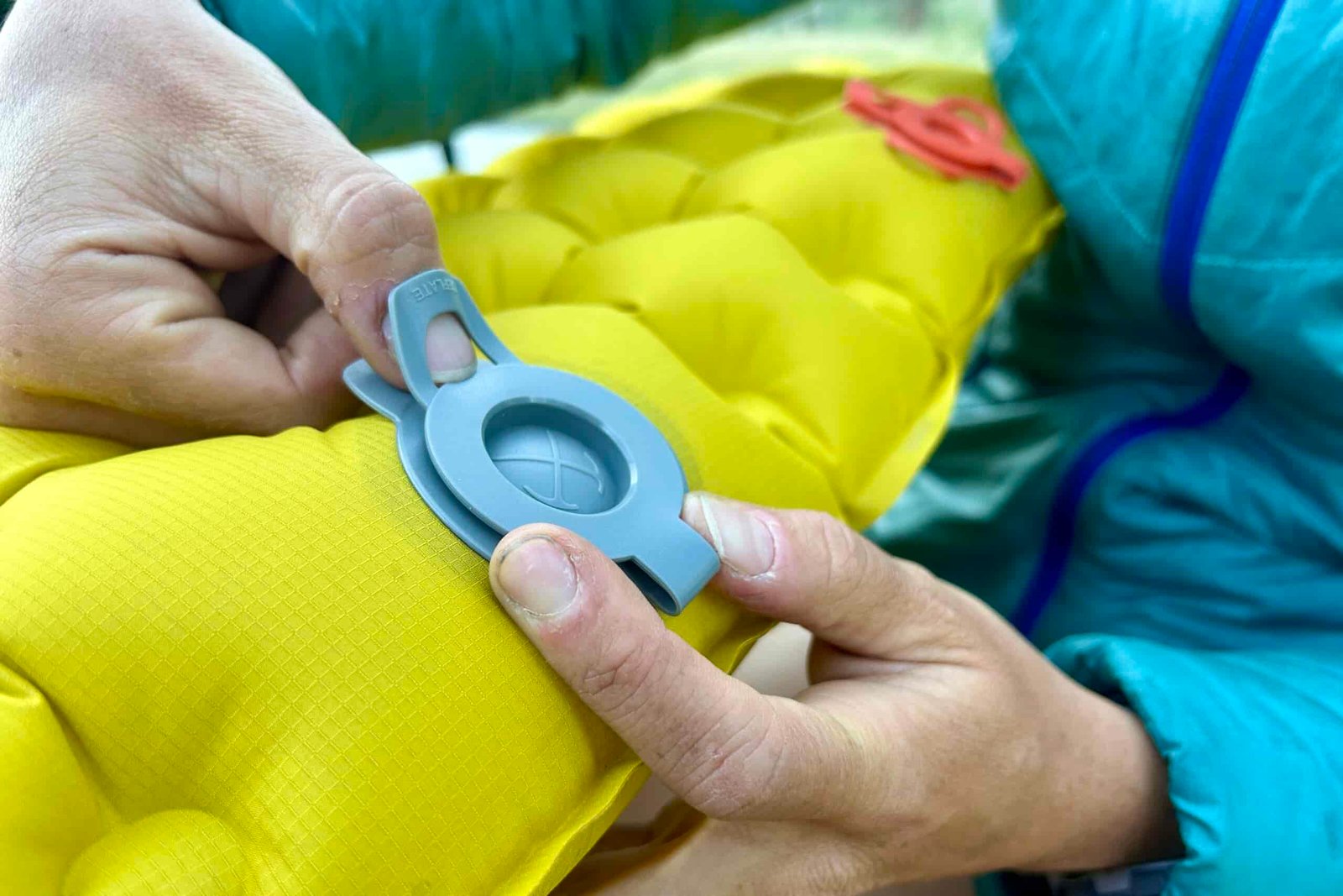 Close up of a person's hands opening a single valve on the REI Helix.
