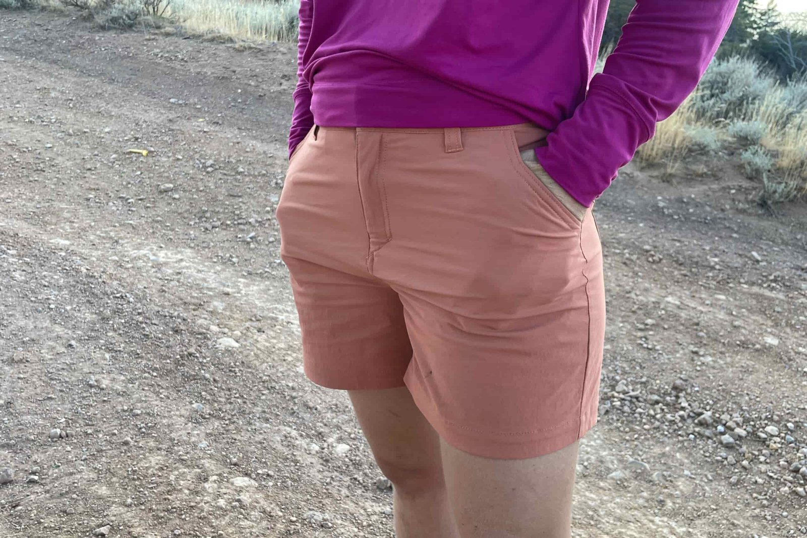 a women with her hands in the waist pockets on a dirt road