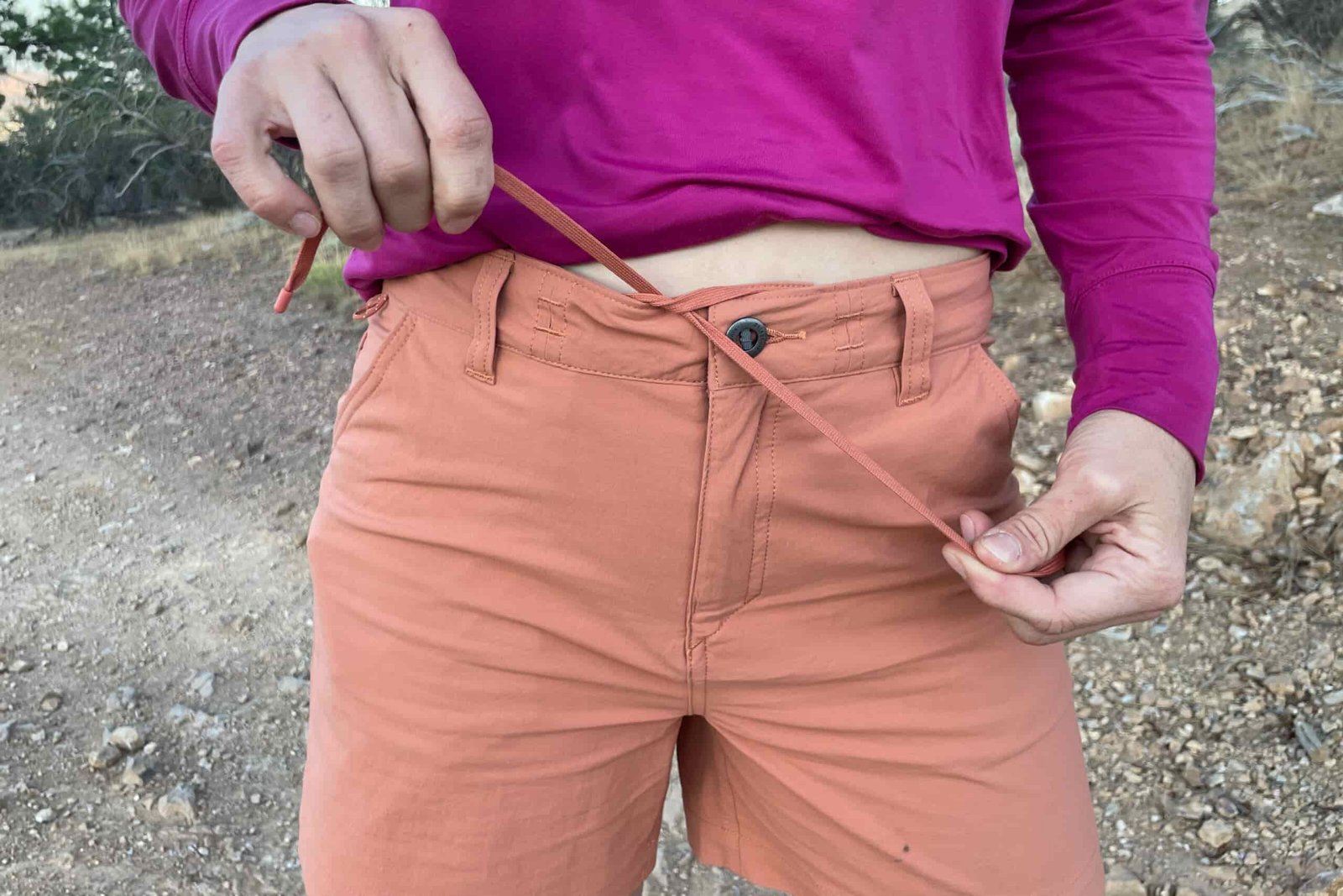 a close up of the front of the patagonia quandary shorts with the women holding the drawstrings to tighten the waist
