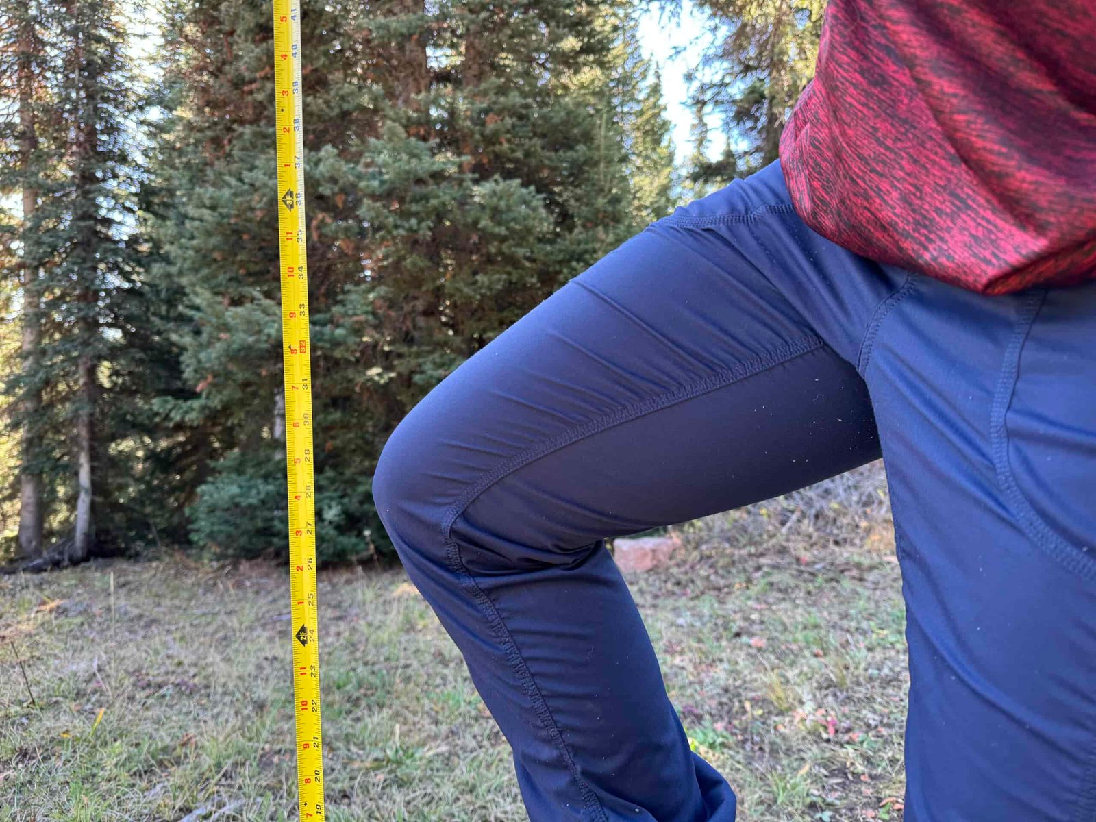 measuring with a measuring tape the hiker's mobility and pant stretch while wearing the north face aphrodite pants
