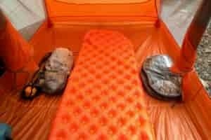 a sea to summit ultralight insulated sleeping pad inflated in a backpacking tent with an ultralight pack and pod beside it.