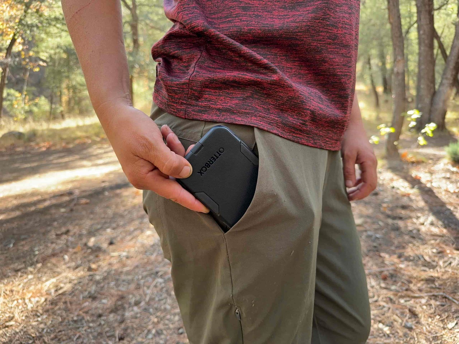 Close up of a phone being placed in the hip pocket of the Happy Hike pants.