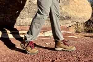 Close up of a man walking in hiking boots, image from knees down.