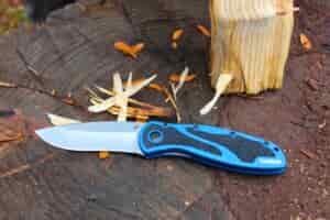 The Kershaw Blur open on a log next to wood shavings