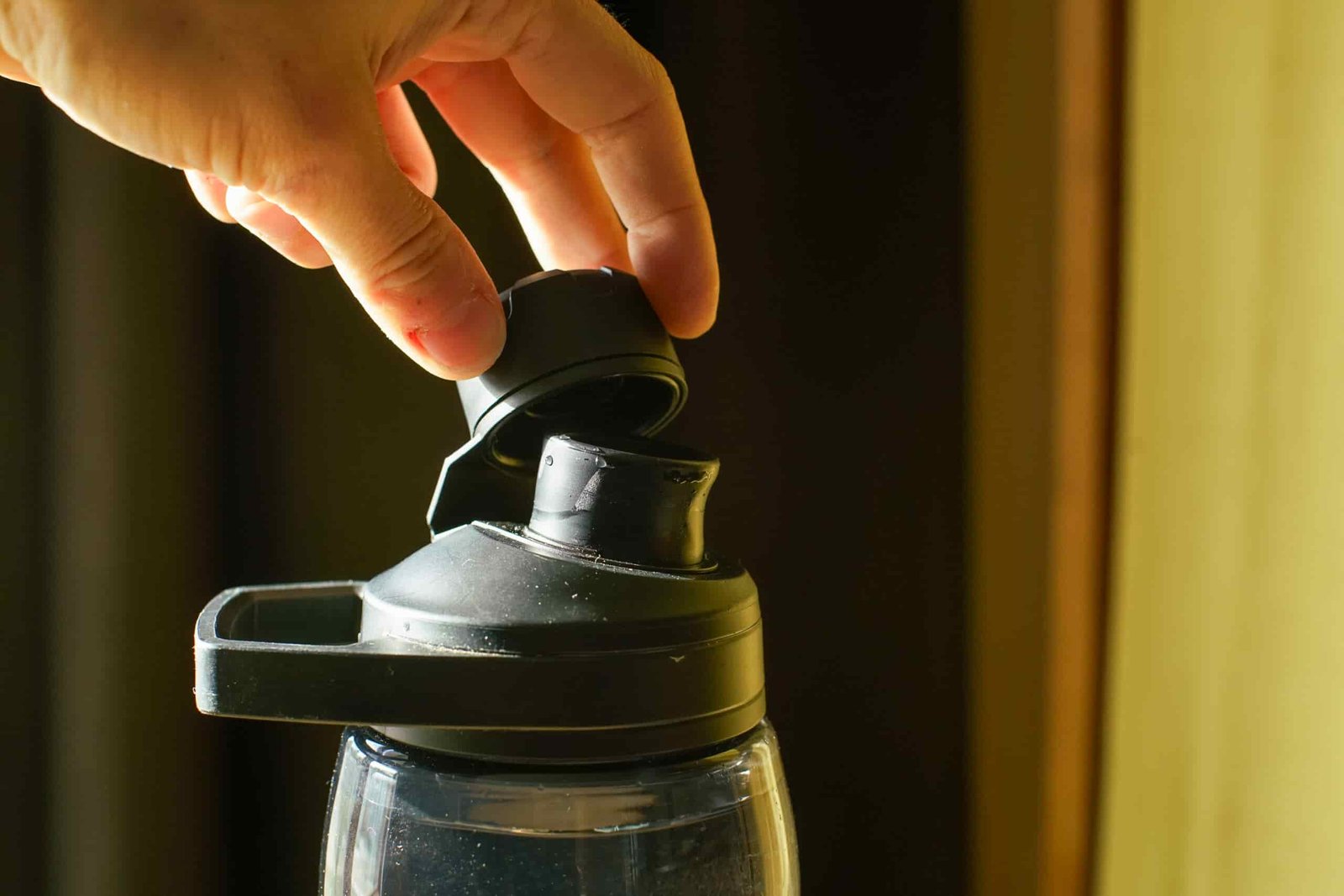 A close up of a hand twisting off the protective cap of the CamelBak Chute Mag Renew water bottle.
