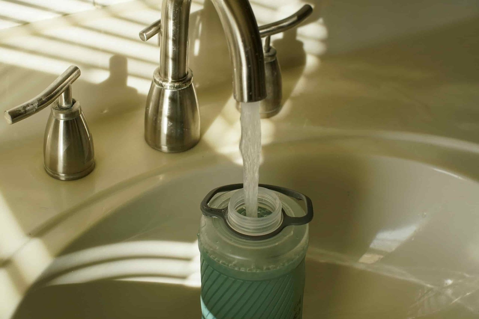 An Hydrapak Flux sits in a sink with water filling the bottle.