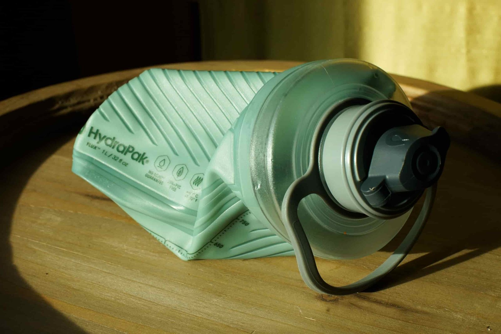 An empty and semi-crushed Hydrapak Flux sits on a table.