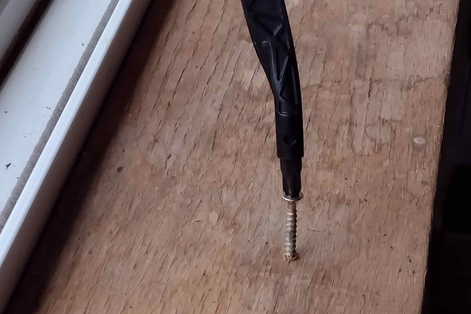 The Gerber Dual Force driving a Phillips screw into wood trim,