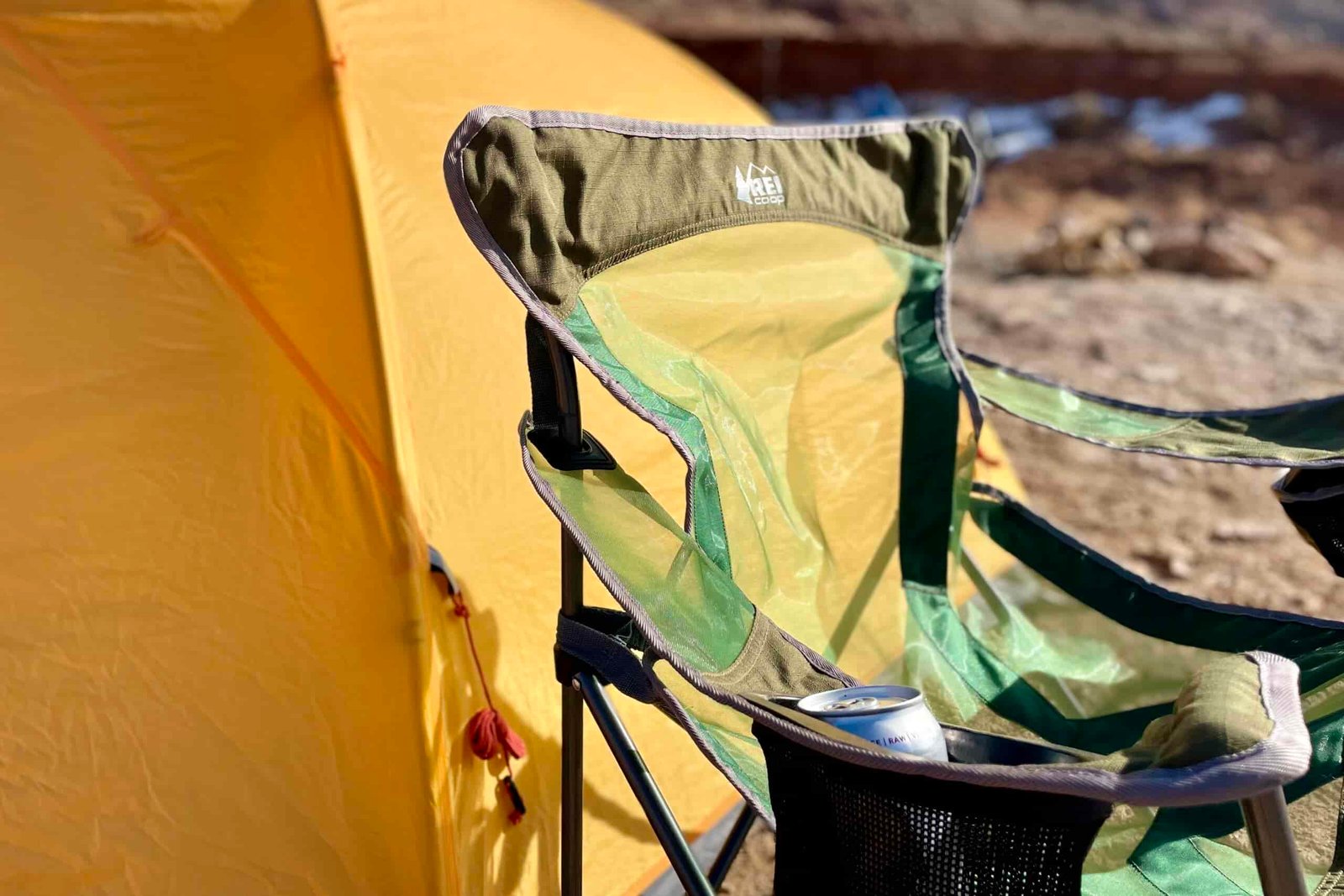 Close up of a camping chair in the desert in front of a tent.