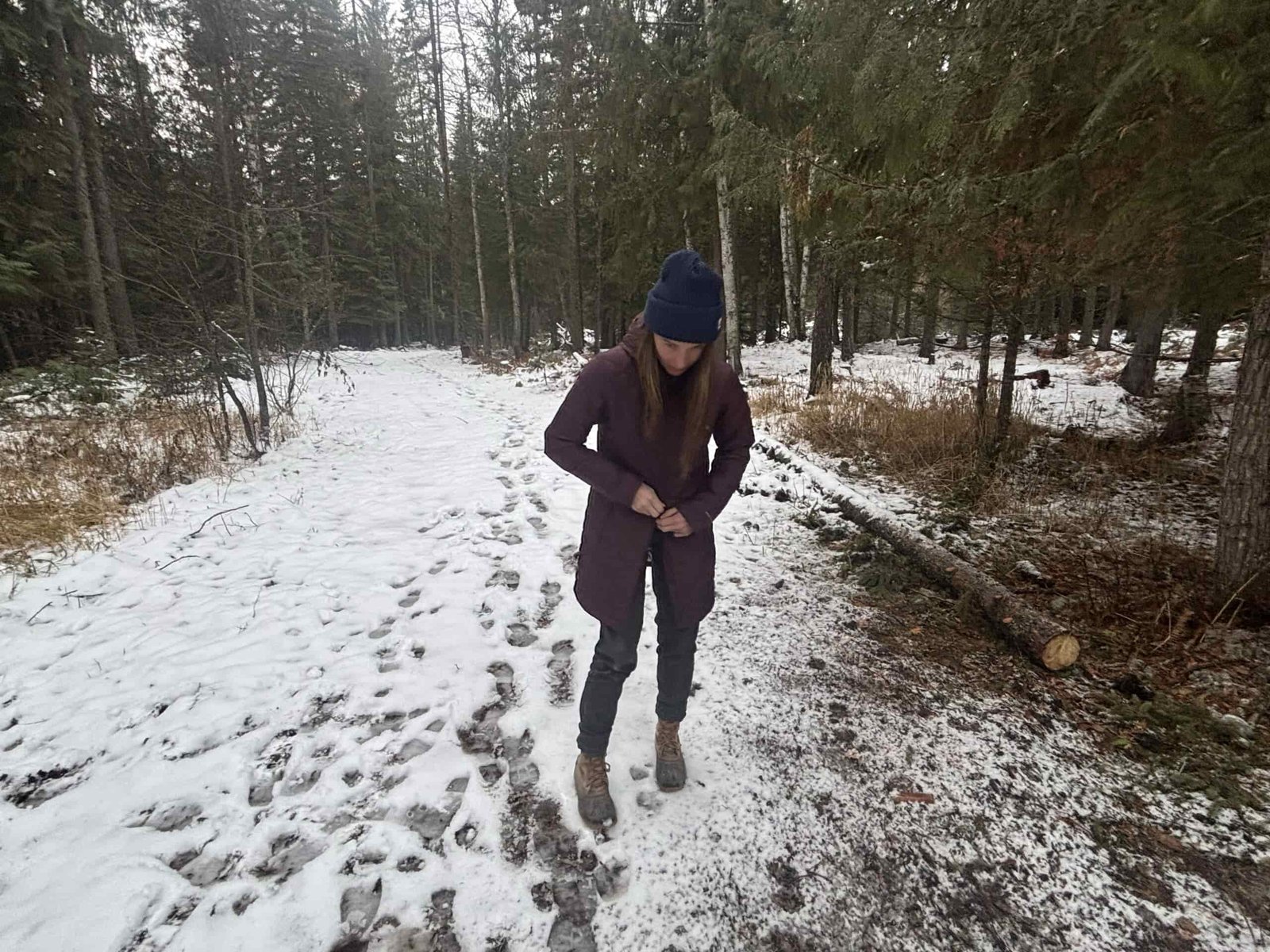 a woman uses the two-way zipper on the columbia heavenly jacket