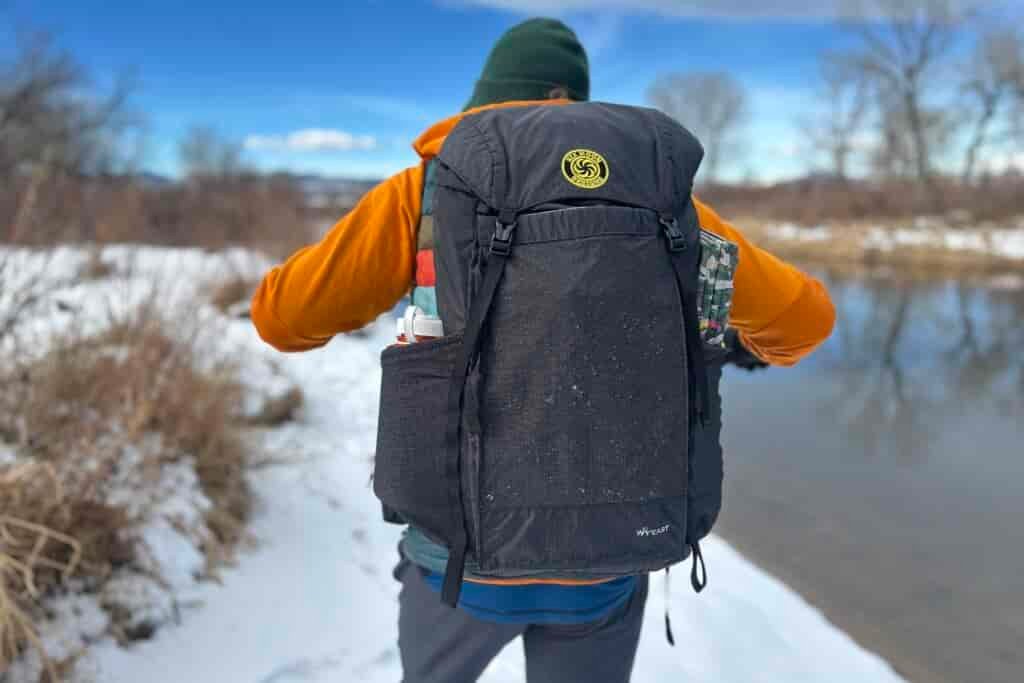 Close up image from behind of a person wearing a backpack.