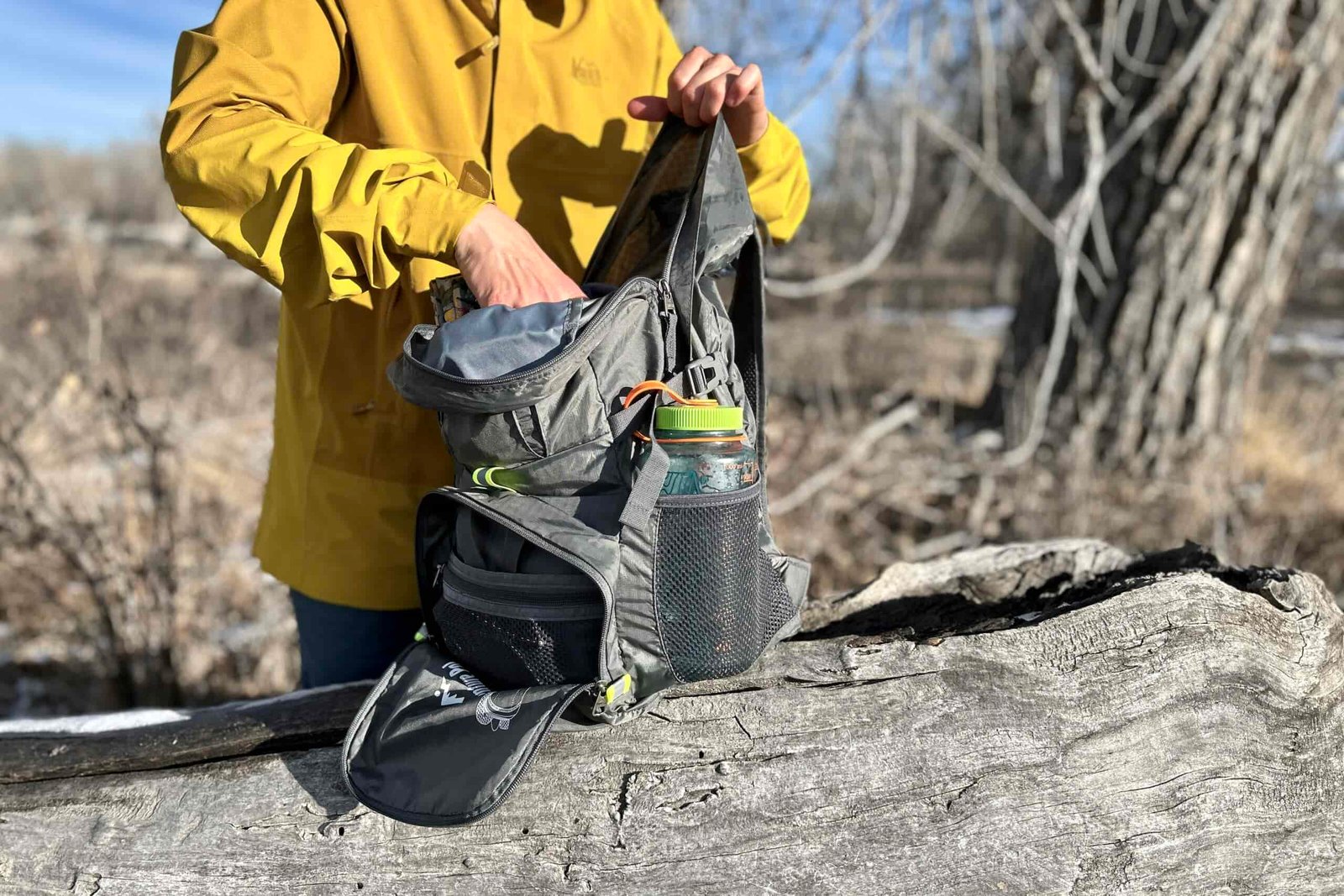 Closeup of a person pulling gear out of their backpack.