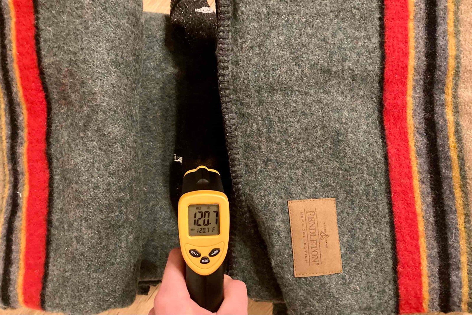 Close-up showing the final reading on the infrared thermometer after a hot sock was wrapped in the Pendleton Yakima Camp Blanket for 30 min. It reads 120.7F.