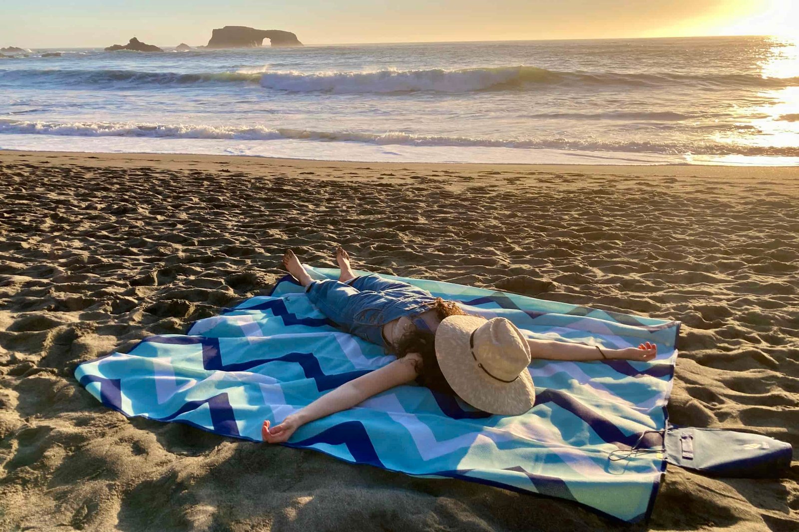 One person spread out on the CGear Multimats Sandlite Sand-free Mat at the beach.