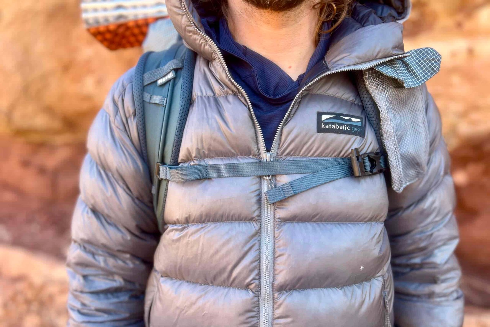 A close-up of the sternum strap of a backpack worn by a hiker.