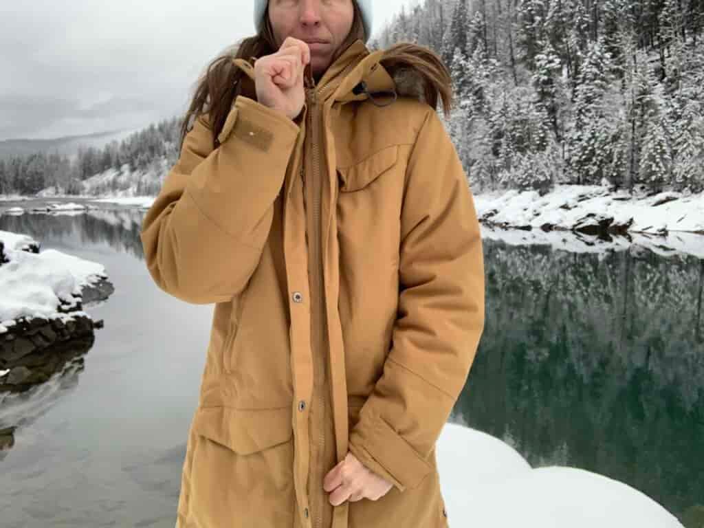 A woman zips the Fjallraven Nuuk